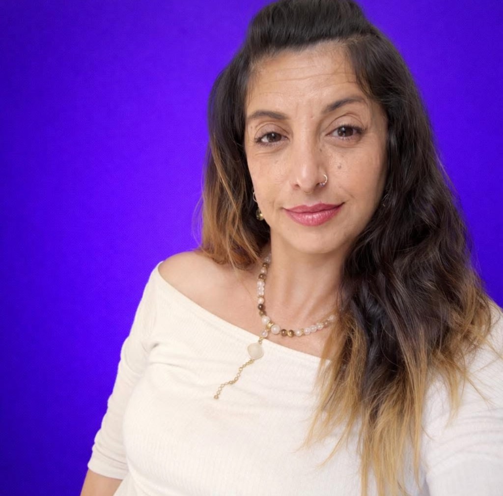 יאנה זוס - יוצרת הקורס, עם מחרוזת אבנים ורקע סגול